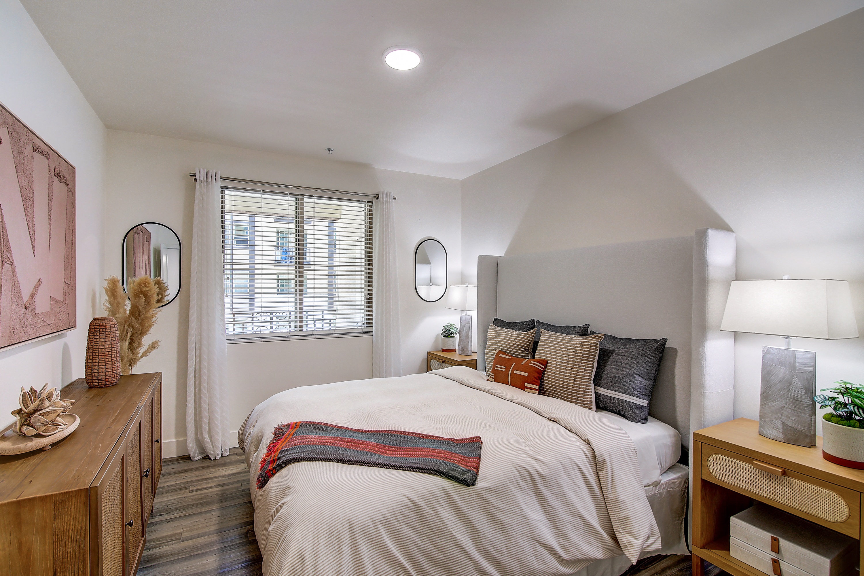 Bright bedroom with a large bed and a window letting in natural light.
